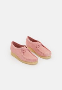 Rosa mockaskor med rund tå, kontrasterande sömmar och en sula av naturligt gummi. Lättviktig och avslappnad design.