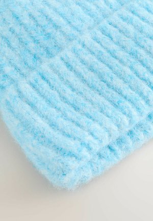 Hele sinine kootud kangas, millel on pehme, udune tekstuur ja vertikaalsed soonilised mustrid. Serv on ümber voltitud, rõhutades paksust ja pehmust.