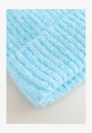 Hele sinine kootud kangas, millel on pehme, udune tekstuur ja vertikaalsed soonilised mustrid. Serv on ümber voltitud, rõhutades paksust ja pehmust.