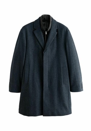 Abrigo gris oscuro hecho de tela texturizada, con cuello de solapa, bolsillos frontales y puños abotonados. Cuenta con un forro interior con cremallera.