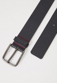 Schwarzer Leder-Gürtel mit roter Naht, ausgestattet mit einer silbernen Metallschnalle und einer glatten Textur. Enthält ein einzelnes Einstell-Loch.