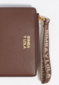 Brązowy portfel teksturowany z złotym wytłoczonym logo "BIMBA Y LOLA" oraz pasującym paskiem na nadgarstek. Posiada zamek błyskawiczny.