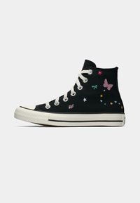 Must musta sneaker valge kummist tallaga, millel on värvikirevad liblikate ja lillede tikandid ning tugevdatud varvas.