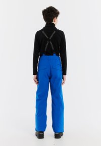 Modré snehové nohavice s nastaviteľnými čiernymi traky majú hladký povrch a praktické bočné vrecká, navrhnuté na zimné aktivity.