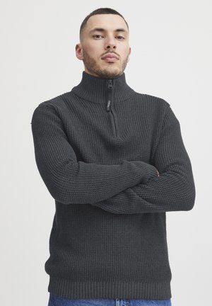 Dunkelgrauer gestrickter Pullover mit hohem Kragen und Reißverschluss. Strukturierter Stoff und gerippter Saum sowie Ärmelbündchen sorgen für eine legere Passform.