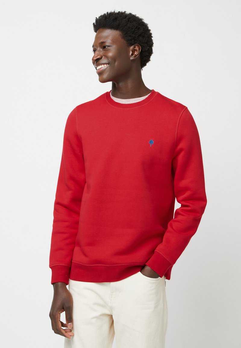 Sweatshirt rouge en mélange de coton, avec un col rond, des manches longues et un petit logo d'arbre bleu sur la poitrine gauche.