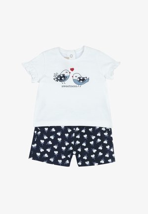 Chemise blanche à manches courtes avec des oiseaux bleus et un motif de cœur rouge intitulé « douceur », associée à un short bleu marine avec des motifs de cœurs blancs.
