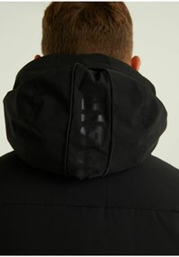 Schwarze Kapuzenjacke mit matter Oberfläche, ausgestattet mit einem Reißverschluss und geprägtem Logo auf der Kapuze. Weicher Stoff, modernes Design.