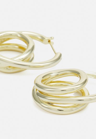 Boucles d'oreilles créoles en métal doré présentant des formes circulaires entrelacées avec une surface lisse et réfléchissante et un fermoir à charnière.