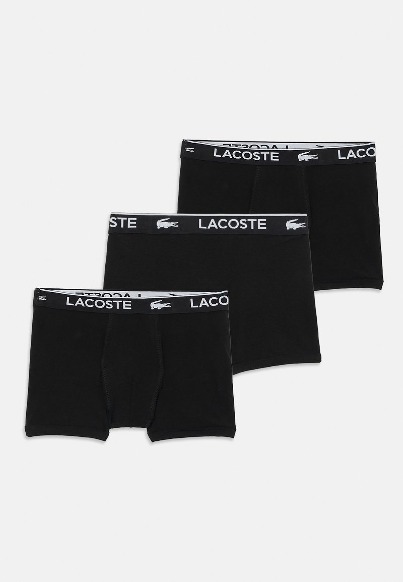 Lacoste juodi šortai, pagaminti iš minkštos medvilnės, su elastiniu juosmeniu su logotipu ir klasikiniu kirpimu. Pakuotėje yra trys vienetai.