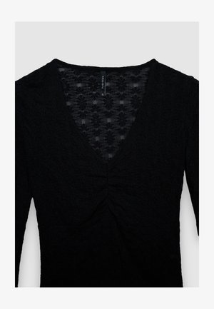 Top nero a maniche lunghe con scollo a V, tessuto strutturato con motivi floreali e dettaglio arricciato al centro del busto.