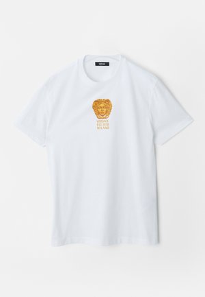 T-shirt blanc à manches courtes avec logo de tête de Méduse dorée et texte "Versace Est. 1978 Milano" centré sur la poitrine.