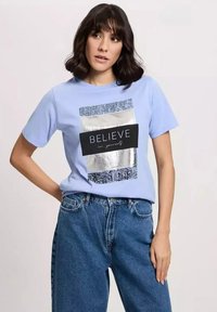 Jasnoniebieska bawełniana koszulka z krótkim rękawem z srebrnym foliowym prostokątnym wzorem z napisem "WIERZ w siebie" oraz wzorzystym bordem.