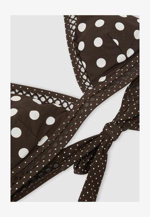 Barna bikini felső nagy fehér pöttyökkel, hálós szegéllyel és megkötő záródással, amely apró fehér pöttyöket tartalmaz egyszínű háttereken.