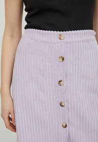 Lila geribbelde rok met een strakke tailleband en vijf houten knopen aan de voorkant, met een gestructureerde stof voor extra detail.