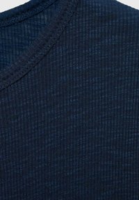 Tmavě modrá, žebrovaná pletenina s texturovaným povrchem. S kulatým výstřihem a jemným švem podél okrajů.