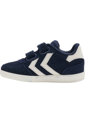 Sloffen voor kinderen in marineblauw met witte chevronstrepen, twee klittenbandsluitingen, een wit hielstuk en een witte zool.