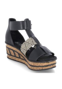 Sandales noires à talon compensé avec semelle en liège texturé. Présente des accents en tissu tissé et un design à bout ouvert. Bride réglable à la cheville.