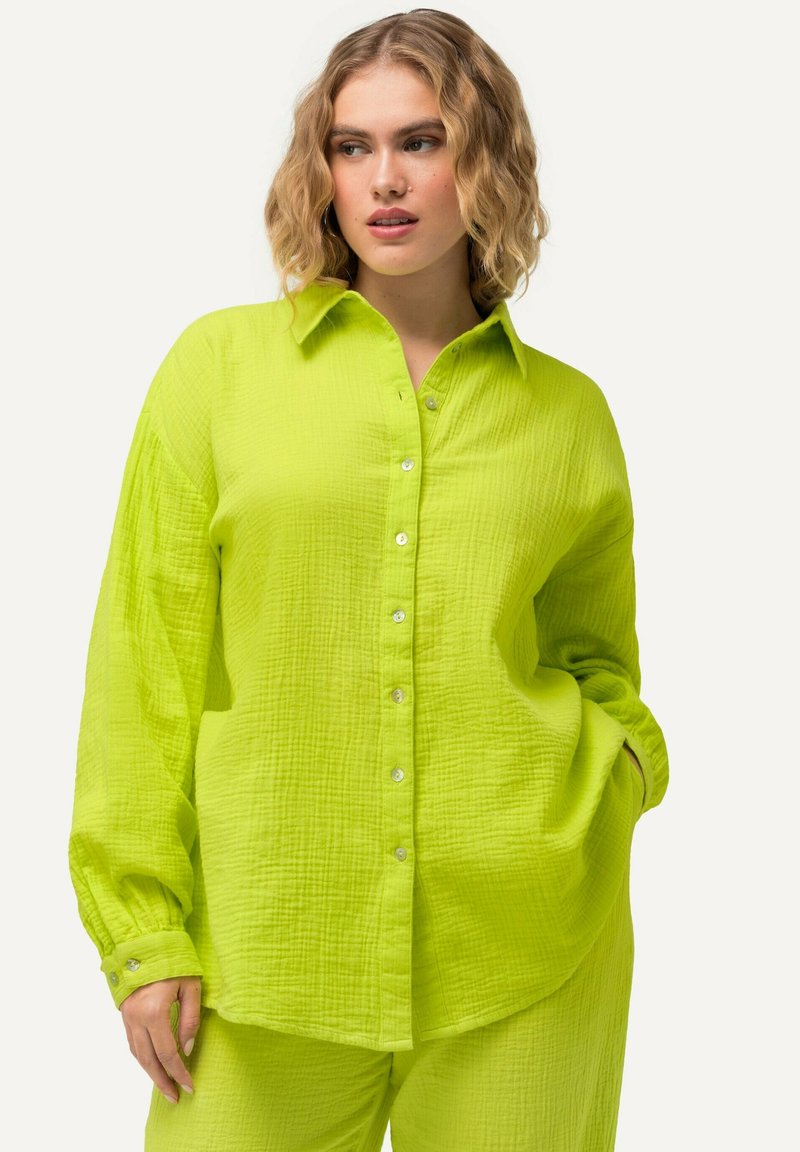 Camicia verde lime, con bottoni, realizzata in un tessuto texture e dal taglio morbido, con maniche lunghe e colletto classico, dotata di bottoni in argento.