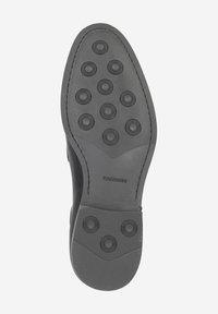 Semelle en caoutchouc noir avec motifs circulaires antidérapants, bout légèrement arrondi, et nom de la marque "MAGNANNI" en relief au bas.