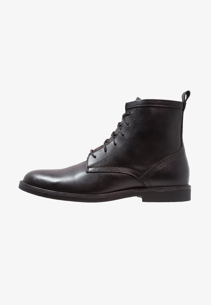 Stivaletto in pelle nera con finitura liscia, punta tonda, lacci frontali e linguetta sul retro; presenta dettagli in cucitura.