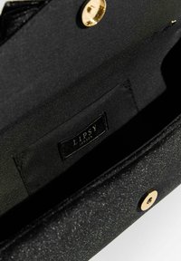Czarna kopertówka o błyszczącej teksturze, z złotym zapięciem zatrzaskowym i metką z napisem "LIPSY LONDON" na wewnętrznej podszewce.