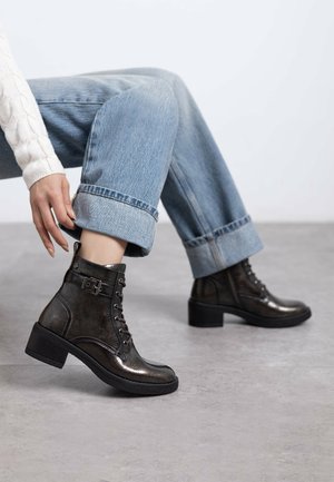 Botas de tobillo de color gris oscuro, hechas de cuero texturizado, con un frente de cordones, un accesorio de hebilla lateral, tacón apilado y suela de goma negra.