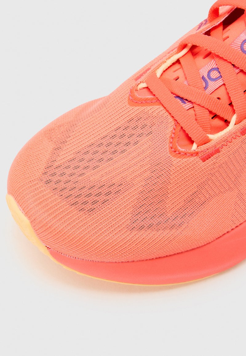 Koraal sport-schoen met een gestructureerde mesh bovenkant, verstevigde neuskap en platte veters. Opvallende kleurverloop van oranje naar geel op de zool.