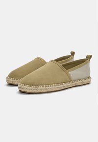 Beige suède instappers met een jute touwzool, met een ronde neus en elastische zijaccenten voor gemakkelijk aan- en uittrekken.