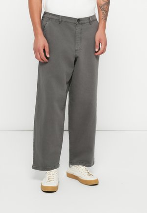Gray cotton trousers with a relaxed fit, featuring front pockets, a single button closure, and a clean hem. Worn with white sneakers.