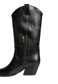 Botas de vaquero de cuero negro con punta afilada, costuras decorativas, cremallera lateral y un tacón grueso. Textura suave y un patrón detallado.