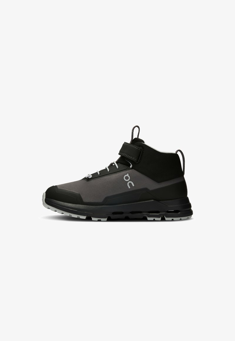 High-top sports shoe in black and gray with a textured fabric upper, adjustable strap, durable sole, and distinctive logo on the side.