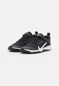 Black athletic shoes with a mesh upper, white accents, lace and Velcro strap, low-top design, and textured rubber sole.
