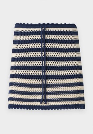 Strikket nederdel med marineblå og cremefarvede horisontale striber, bølgede kanter og marineblåt snørebånd i taljen.