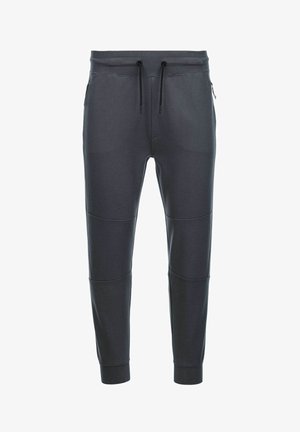 Pantalones de chándal gris oscuro fabricados en tejido suave, con cintura elástica ajustable, dos bolsillos laterales con cremallera y detalles en panel en las piernas.