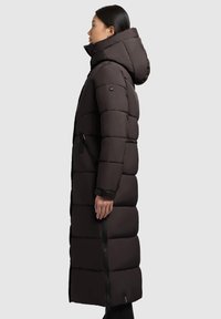 Pikk, kobed must talvejope kapuutsiga, millel on horisontaalsed tikandiosad, küljevetked ja pehme tekstuur.