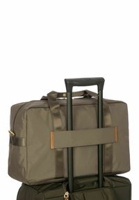 Borsa da viaggio verde oliva scuro con forma rettangolare, dotata di una cerniera superiore, due manici corti, tracolla regolabile e manico retrattile.