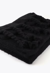 Svart ullfilt med strukturerade, knutna detaljer. Materialet verkar mjukt med ett tjockt, mysigt utseende och subtila ytanpassningar.