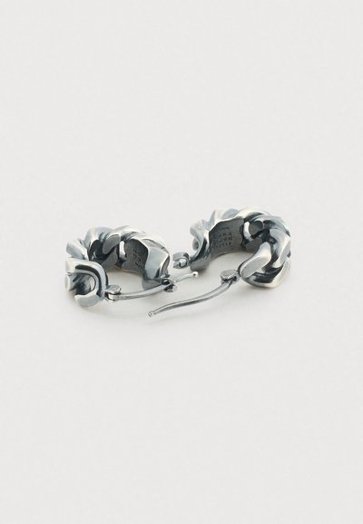 Ασημένια σκουλαρίκια κρίκοι με στριφτό σχέδιο. Λείο υφή και ανακλαστική επιφάνεια. Διαθέτουν μηχανισμό ασφαλούς κλεισίματος.