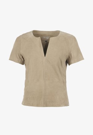 Haut beige à manches courtes avec un col en V et une coupe droite. Fabriqué en suède doux, avec des coutures visibles et une étiquette logo à l'ourlet.