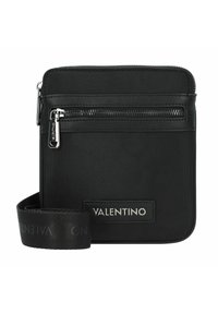 Černá crossbody taška vyrobená z texturovaného nylonu se zipovou kapsou, s označením na kožené nášivce a nastavitelným látkovým popruhem.