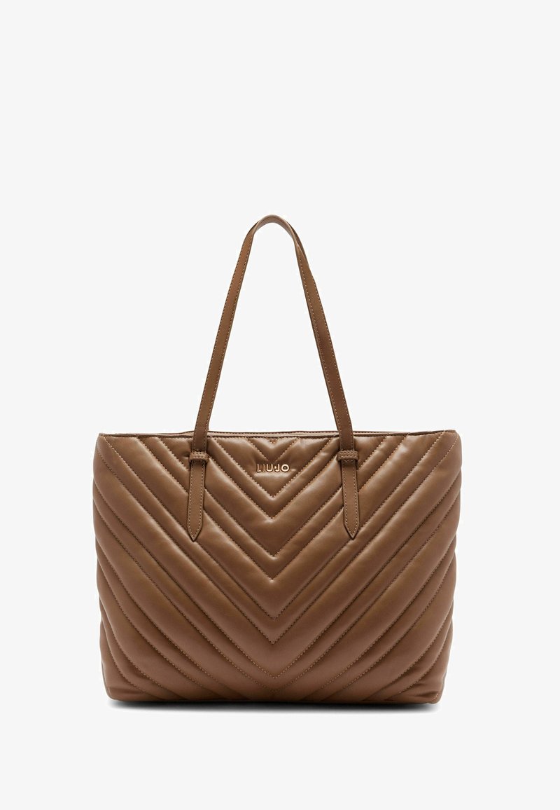 Bruine leren tote bag met chevron-quiltpatroon, voorzien van twee schouderbanden en een metalen logo aan de voorkant. Gladde textuur.
