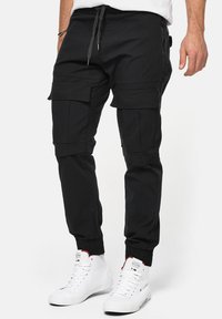 DENNIS - Reisitaskuhousut - black