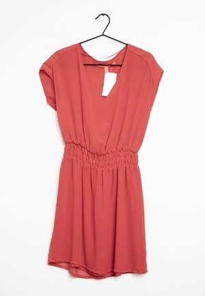 Robe couleur rouille avec un décolleté en V profond, des manches courtes et une taille élastique. Tissu doux et léger avec une jupe fluide.