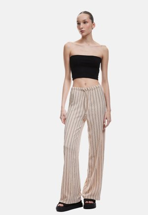 Beige striped wide-leg pants with a drawstring waist, paired with a black strapless top and chunky black sandals. Smooth texture, casual style.