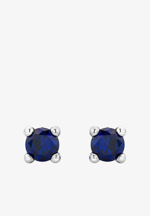 Runde Ohrringe mit einem tiefblauen Edelstein, der in einem silbernen Vier-Zacken-Design gefasst ist. Polierte Silberakzente verleihen dem Gesamtbild zusätzlichen Glanz.