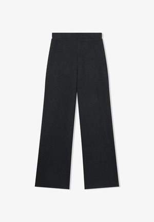 Czarne, szerokie spodnie wykonane z miękkiego materiału o gładkiej fakturze oraz elastycznym pasie dla wygody. Brak widocznych wzorów lub elementów metalowych.