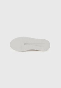 Hvid gummisåle til sneakers med et struktureret grebsmønster og en glat hæl. Har en central rille og hævede kantlinjer.
