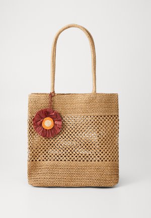 Borsa tote in paglia intrecciata di colore marrone chiaro con due manici e un accento decorativo a forma di fiore in rosso, arancione e giallo su un lato.
