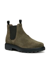 Botas de tobillo de ante verde oliva con paneles laterales elásticos, lengüetas en la parte superior y suelas de goma negras que presentan un diseño con textura para mayor tracción.